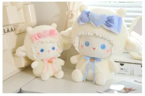 Primo piano di due peluche di pecora con fiocchi in pizzo blu e rosa su scrivania bianca