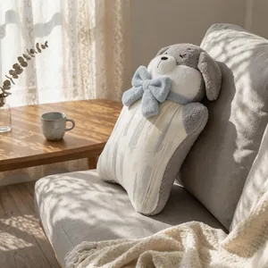 Cute plush puppy decorative pillow with blue bow tie on a cozy sofa in natural sunlight