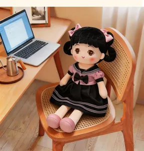 Detail of a cute plush girl doll in school uniform sitting on a wooden chair indoors.