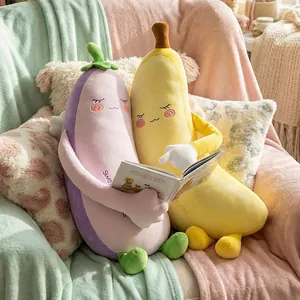 Niedliche lange Plüschkissen in Bananen- und Auberginenform auf einem Sofa