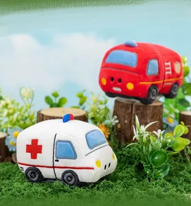 Plush ambulance and fire truck toy cars in a playful miniature outdoor forest scene.