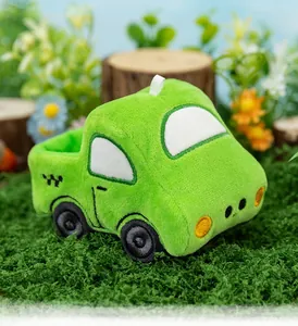 Detailed view of a soft green cartoon truck plush toy placed in a forest-themed setting.
