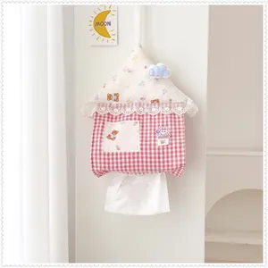Cute house-shaped hanging tissue holder with red gingham pattern on a white wall