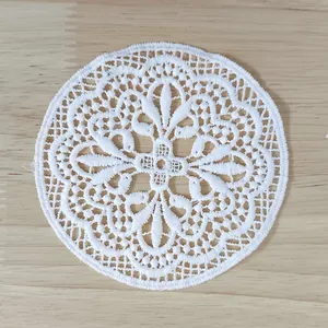 Close-up detail of a white retro water-soluble lace coaster with hollow floral embroidery.