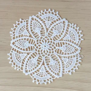 Close-up detail of a vintage white water-soluble lace coaster with intricate patterns