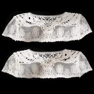 Détail macro d'un châle en dentelle brodée de soie de lait blanche à motifs floraux