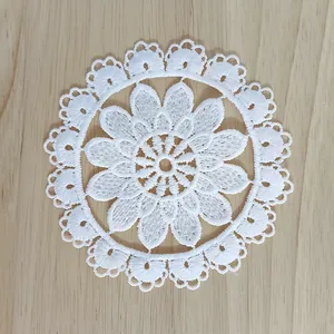 Detailed view of a white vintage floral lace coaster with delicate hollow embroidery.