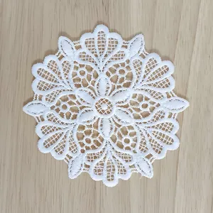 Detailed view of the intricate white hollow floral embroidery on a vintage lace patch