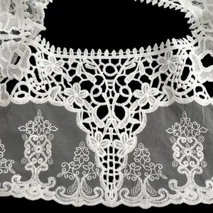 Gros plan sur la broderie florale blanche complexe du châle en dentelle de soie de lait