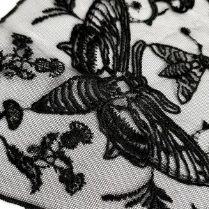 Makroaufnahme der schwarzen Schmetterlingsstickerei auf feinem Netzgewebe.