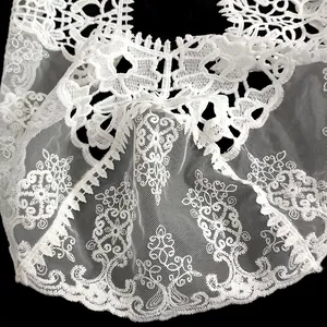 Gros plan sur la broderie florale d'un châle en dentelle de soie de lait blanche