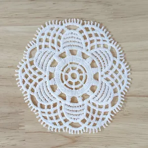 Detailed view of a vintage white lace circular patch with hollow embroidery patterns
