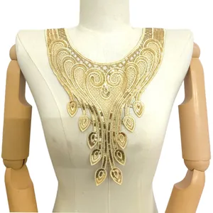 Close-up detail of gold sequin embroidered lace collar with ethnic pattern on mannequin.