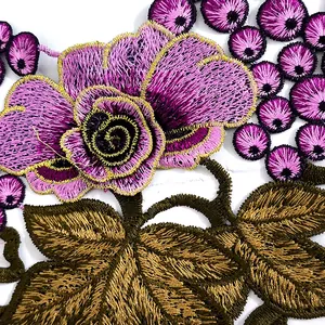 Detailed close-up of intricate pink floral and grape embroidery with gold thread