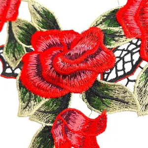 Detaillierte Nahaufnahme von roter Rosenstickerei und Blumenspitze auf einer Applikation