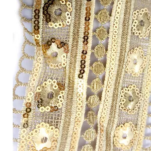Nahaufnahme der aufwendigen Goldfadenstickerei mit glänzenden Pailletten auf Spitze