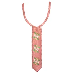 Detail of coral embroidered lace collar with elegant floral patterns in a tie shape