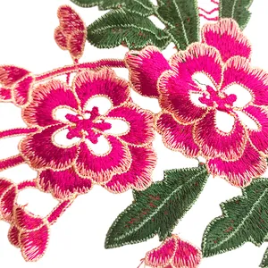 Macro shot of vibrant pink and green floral embroidery patch showing intricate stitching