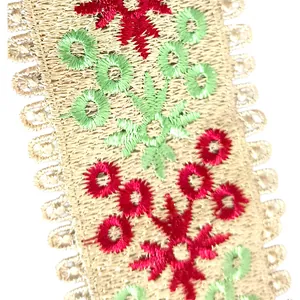 Detailed macro view of heavy embroidered lace trim featuring red and green floral patterns