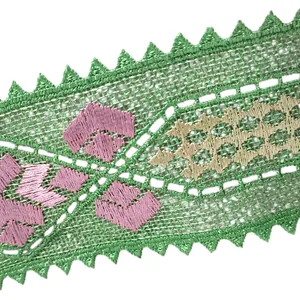 Detailed close-up of green embroidered lace trim with pink floral patterns for garments