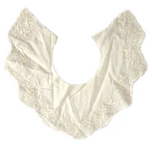 Macro view of white cotton detachable collar with floral hollow embroidery detail