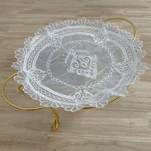 Detail van een witte organza kanten placemat met elegante etnische borduurpatronen hier