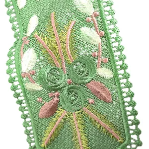 Detailed macro shot of heavy embroidered green lace collar with colorful floral patterns