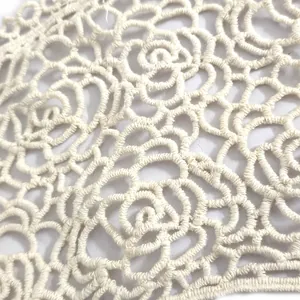 Macro detail of cream cotton embroidered lace collar with elegant rose pattern embroidery