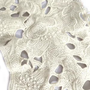Macro view of intricate hollow-out floral embroidery on white cotton lace collar