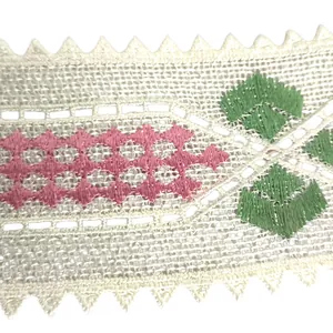 Close-up of embroidered lace collar applique with pink and green geometric patterns