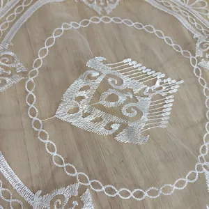Detailopname van fijn wit borduurwerk op een elegante kanten organza placemat