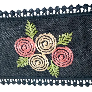 Detail view of vibrant floral embroidery and intricate mesh on black lace collar.