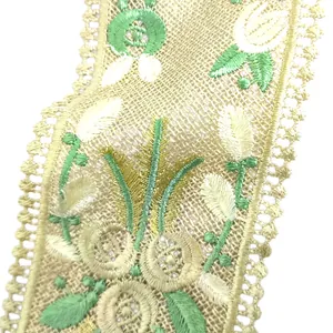 Macro detail of intricate green and white floral embroidery on yellow lace collar