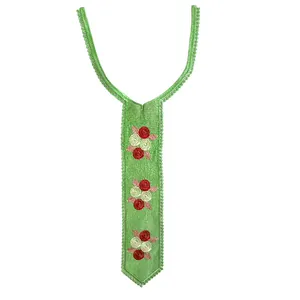 Close-up detail showing intricate green embroidered lace false collar with red floral pattern.