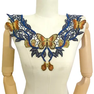Détail d'une applique de dentelle brodée de papillons colorés sur un mannequin