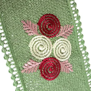 Close-up macro view of intricate spiral flower embroidery on green mesh fabric