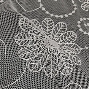 Macro detail van witte mesh stof met ingewikkelde bloemen kant borduurwerk voor vakantie