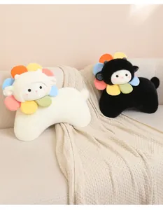Dettaglio dei cuscini di peluche a forma di pecora girasole bianchi e neri su divano