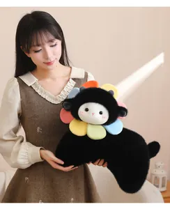 Dettaglio di un cuscino di peluche a forma di agnello girasole tenuto da una modella