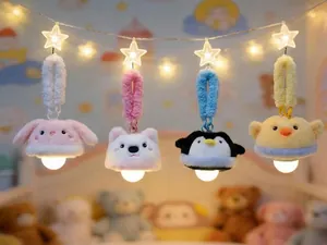 Detail of four cute animal plush night light pendants hanging on star string lights