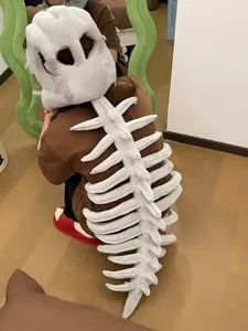Detalle de la vista trasera del divertido gorro de peluche con esqueleto de dinosaurio