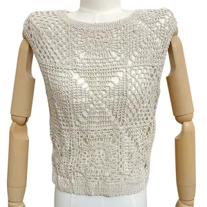 Detail view of a white crochet hollow-out knit top with intricate lace patterns