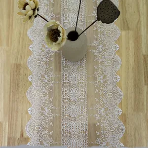 Detailed view of white vintage lace table runner with intricate floral embroidery