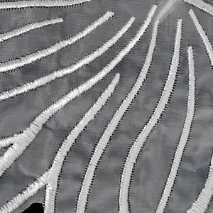 Nahaufnahme des Makrodetails eines weiß bestickten Organza-Spitzenflügel-Patches Textur