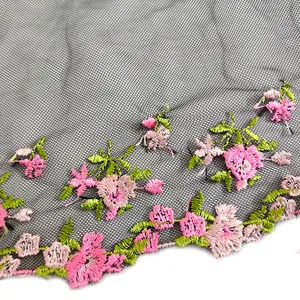 Detailed view of intricate pink floral embroidery on delicate black mesh lace trim