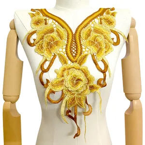 Gros plan d'une applique de col en dentelle brodée de fleurs dorées sur un mannequin blanc