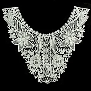 Detailed macro close-up of white floral lace collar with intricate hollow embroidery