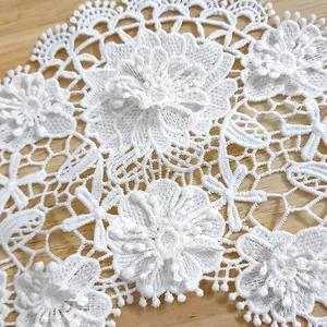 Close-up detail of white 3D floral embroidered lace applique for garment decoration