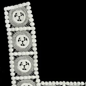 Detailed view of white milk silk embroidered lace trim with hollow floral pattern