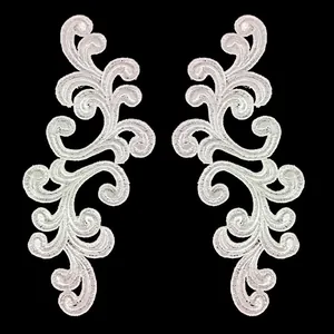 Detailed view of white symmetric floral embroidery lace patches for DIY crafts.